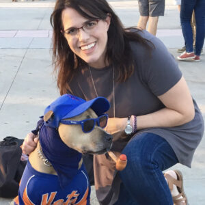 DeAnn Mooney with a dog decked out in NY Mets gear and sunglasses